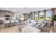 Open concept living room with large windows, neutral decor, and a view of the outdoor landscape at 17904 Tavernside Trl, Bradenton, FL 34211