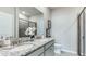 Modern bathroom with dual sinks, granite countertops, and a glass-enclosed shower at 18047 Cropside Trl, Lakewood Ranch, FL 34211