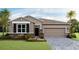 Charming single-story home features a stone veneer, a two-car garage and a well-manicured lawn at 18228 Beach Ranch Ter, Lakewood Ranch, FL 34211