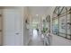 Bright hallway features modern decor, mirrors, tiled floors, and views into the living spaces at 18228 Beach Ranch Ter, Lakewood Ranch, FL 34211