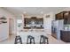 Eat-in kitchen with granite island, black cabinets, stainless appliances and tile floors at 18228 Beach Ranch Ter, Lakewood Ranch, FL 34211