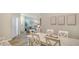 A dining room is staged with a white table and seating for six next to an open living room at 18324 Cropside Trl, Lakewood Ranch, FL 34211