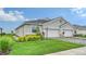 Charming home with a two-car garage, lush green lawn, and well-maintained landscaping at 18324 Cropside Trl, Lakewood Ranch, FL 34211