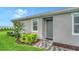 Inviting front entrance with a gray door, charming landscaping, and a well-maintained walkway at 18324 Cropside Trl, Lakewood Ranch, FL 34211