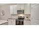 A view of a stove, microwave and upper cabinets in this bright kitchen at 18324 Cropside Trl, Lakewood Ranch, FL 34211