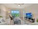 Bright living room with comfortable seating, stylish decor, and a sliding glass door to the outside at 18324 Cropside Trl, Lakewood Ranch, FL 34211