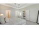 Spacious main bedroom with tray ceilings and access to the bathroom and living room at 18324 Cropside Trl, Lakewood Ranch, FL 34211