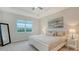 The main bedroom is staged with a bed, two side tables, and a view to the green exterior at 18324 Cropside Trl, Lakewood Ranch, FL 34211