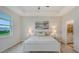 Spacious main bedroom with a tray ceiling, large window, and en-suite bathroom access at 18324 Cropside Trl, Lakewood Ranch, FL 34211
