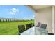 Inviting covered patio with table and chairs overlooking the lush green lawn at 18324 Cropside Trl, Lakewood Ranch, FL 34211