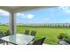 Inviting covered patio with table and chairs overlooking the lush green lawn at 18324 Cropside Trl, Lakewood Ranch, FL 34211