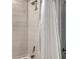 Detailed shower featuring white tile walls, rainfall shower head, and bronze fixtures at 18324 Cropside Trl, Lakewood Ranch, FL 34211