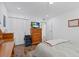 This bedroom features a wooden dresser with TV, along with a closet and light-colored bedspread at 202 Bedford Trl # 120, Sun City Center, FL 33573