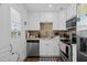 Modern kitchen with stainless steel appliances, white cabinets, and a stylish backsplash at 202 Bedford Trl # 120, Sun City Center, FL 33573