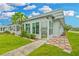 Bright sunroom with large windows, tile accents, and a cozy spot for relaxing and enjoying the view at 202 Bedford Trl # 120, Sun City Center, FL 33573