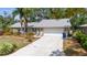 Charming single-story home featuring a stone facade and attached two car garage, enhanced by lush landscaping and mature trees at 2204 67Th W St, Bradenton, FL 34209