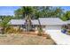 Charming single-story home showcasing stone accents, a well-manicured lawn, and lush landscaping with tropical palms at 2204 67Th W St, Bradenton, FL 34209