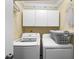 Practical laundry room with a washer, dryer, and white overhead cabinets for storage at 2204 67Th W St, Bradenton, FL 34209