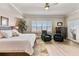 Bright main bedroom featuring a large bed, two comfy chairs, and plantation shutters at 2825 Terra Ceia Bay Blvd # 1804, Palmetto, FL 34221