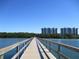 Picturesque view of a wooden pier stretching over the water towards modern condo buildings, highlighting waterfront living at 2825 Terra Ceia Bay Blvd # 1804, Palmetto, FL 34221