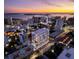 Stunning aerial view of a modern, luxurious condo building overlooking the city at sunset at 290 Cocoanut Ave # 8B, Sarasota, FL 34236