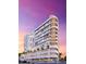 Exterior view of a modern building, highlighting its curved balconies and elegant design against a vibrant sunset backdrop at 290 Cocoanut Ave # 8B, Sarasota, FL 34236