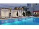 Outdoor pool area with cabanas, sun loungers, and lush landscaping at 290 Cocoanut Ave # 8B, Sarasota, FL 34236