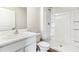 Bright bathroom featuring a white vanity, sink, toilet, and a shower with built-in shelving at 3219 Bitterroot Ln, Lakewood Ranch, FL 34211