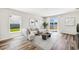 Bright living room with plank floors, modern furnishings, and sliding glass doors to the backyard at 3219 Bitterroot Ln, Lakewood Ranch, FL 34211