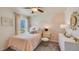 Bright bedroom with soft pink accents, decorative wall painting, comfy bed, and view to the outside at 3278 Rock Sound St, Bradenton, FL 34208