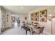 Open-concept dining area with modern table, chairs, bench, decorative wall art, and seamless flow into the living room at 3278 Rock Sound St, Bradenton, FL 34208