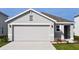 Two car garage door and driveway to a one-story home with gray stucco exterior under a bright blue sky at 3278 Rock Sound St, Bradenton, FL 34208