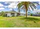 Single-story home with white exterior, a front yard, and a driveway leading to an attached garage at 3303 Cambridge W Dr, Bradenton, FL 34205