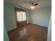 Bedroom with wood flooring, fan, and window with curtain for comfortable private space at 3339 Duar Ter, North Port, FL 34291