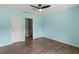 This bedroom features wood-look floors, a ceiling fan and soft blue walls at 3339 Duar Ter, North Port, FL 34291