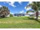 Single-story home with a well-maintained lawn, palm trees, screened-in front porch, and solar panels at 3339 Duar Ter, North Port, FL 34291