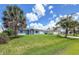 Charming single-story home with a well-manicured lawn and beautiful palm trees against a blue sky at 3339 Duar Ter, North Port, FL 34291