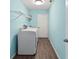 Laundry room with blue walls, wood-look floors, and washer and dryer at 3339 Duar Ter, North Port, FL 34291