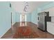 Bright living room featuring wood floors, stainless steel refrigerator and a decorative entry door at 3339 Duar Ter, North Port, FL 34291