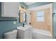 Well-lit bathroom featuring a combination tub/shower, neutral tile, updated vanity, and a light blue accent wall at 3631 Palm Dr, Punta Gorda, FL 33950