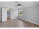 This bedroom has a ceiling fan, wood floors, neutral paint, and a window with a view of the well-manicured lawn at 3631 Palm Dr, Punta Gorda, FL 33950
