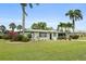 Charming single-story home boasts a well-manicured lawn, mature trees, and a two-car garage at 3631 Palm Dr, Punta Gorda, FL 33950