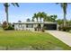 Charming single-story home boasts a well-manicured lawn, mature trees, and a two-car garage at 3631 Palm Dr, Punta Gorda, FL 33950