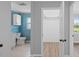 View of the hallway with a walk in closet, and blue bathroom with white vanity and toilet at 3631 Palm Dr, Punta Gorda, FL 33950