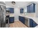 This modern kitchen features blue cabinets, stainless appliances, and white quartz countertops at 3631 Palm Dr, Punta Gorda, FL 33950
