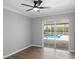 Bright living room boasts wood flooring and a ceiling fan, with sliding doors opening to a screened-in pool at 3631 Palm Dr, Punta Gorda, FL 33950