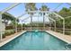 Enclosed backyard pool with clear blue water is surrounded by a screened-in lanai at 3631 Palm Dr, Punta Gorda, FL 33950