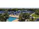 Overhead view of a community pool and tennis courts surrounded by lush greenery and palm trees at 3634 Torrey Pines Way Way, Sarasota, FL 34238