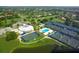 Panoramic aerial view of this community featuring tennis courts, a pool, a clubhouse, and manicured green spaces at 3634 Torrey Pines Way Way, Sarasota, FL 34238