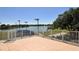 Tiled patio providing tranquil views of a lake and tennis courts surrounded by secure fencing at 3634 Torrey Pines Way Way, Sarasota, FL 34238
